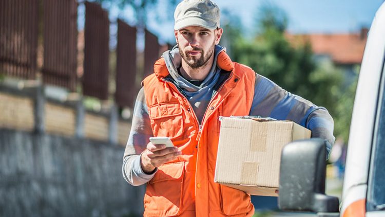 Chauffeur livreur consultant sa tournée sur son smartphone