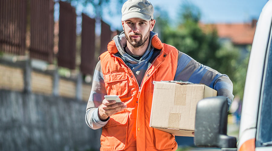 Chauffeur livreur consultant sa tournée sur son smartphone