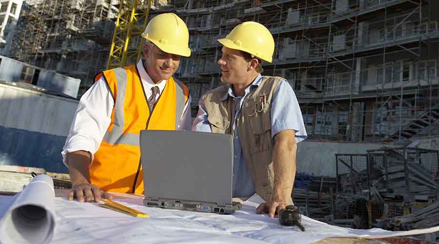 Responsable de projet vérifiant l'avancée du chantier sur plans.